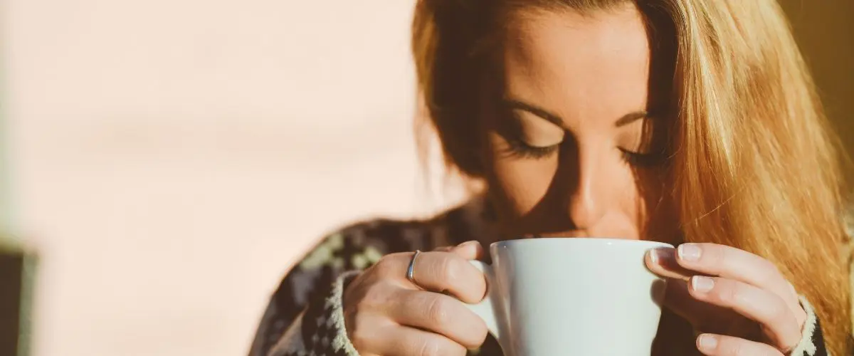 Eine Frau hält eine Tasse in den Händen.