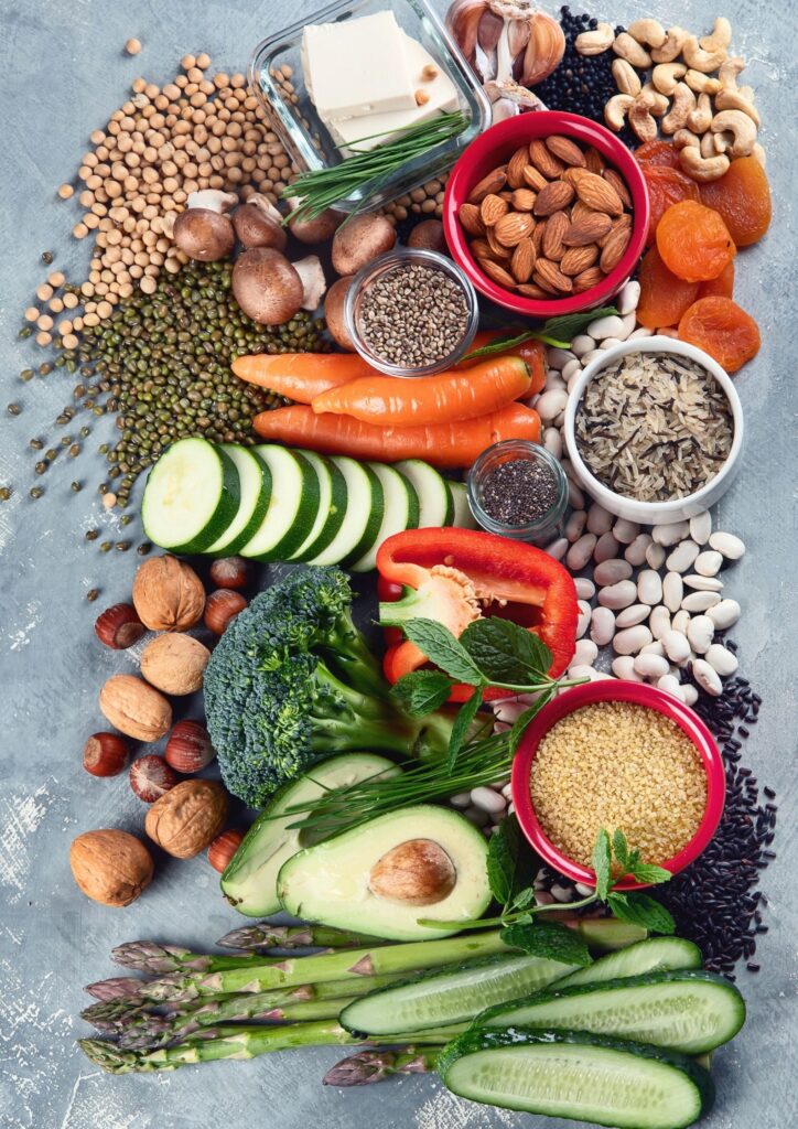 Nebeneinander liegen verschiedenes Gemüse, Nüsse und Kerne.