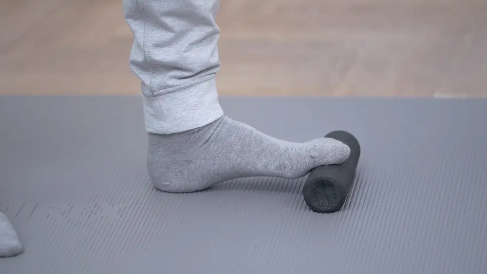 Fuß auf einer kleinen Faszienrolle