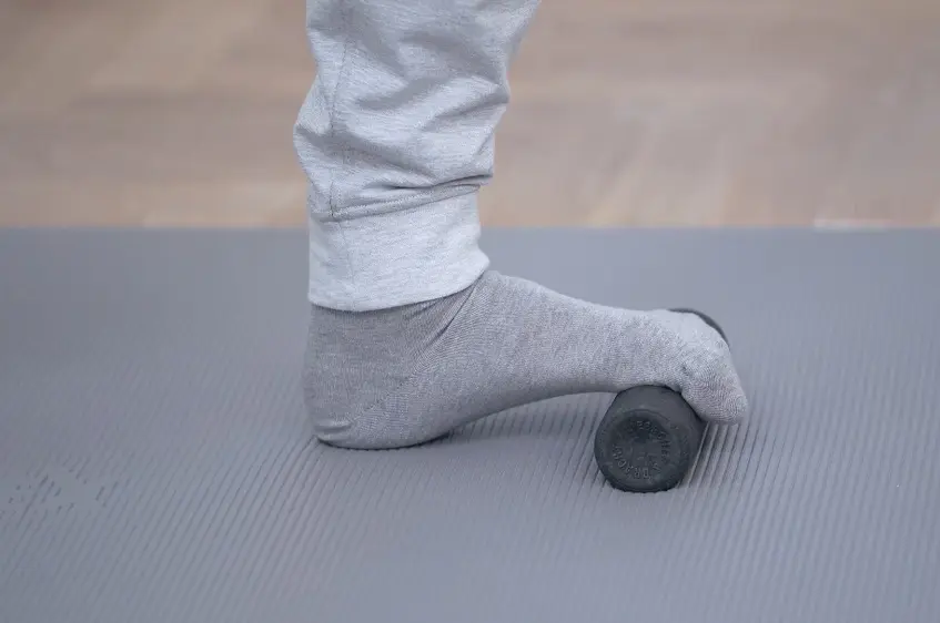 Fuß auf einer kleinen Faszienrolle