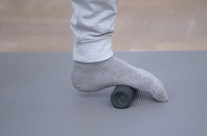 Fuß auf einer kleinen Faszienrolle