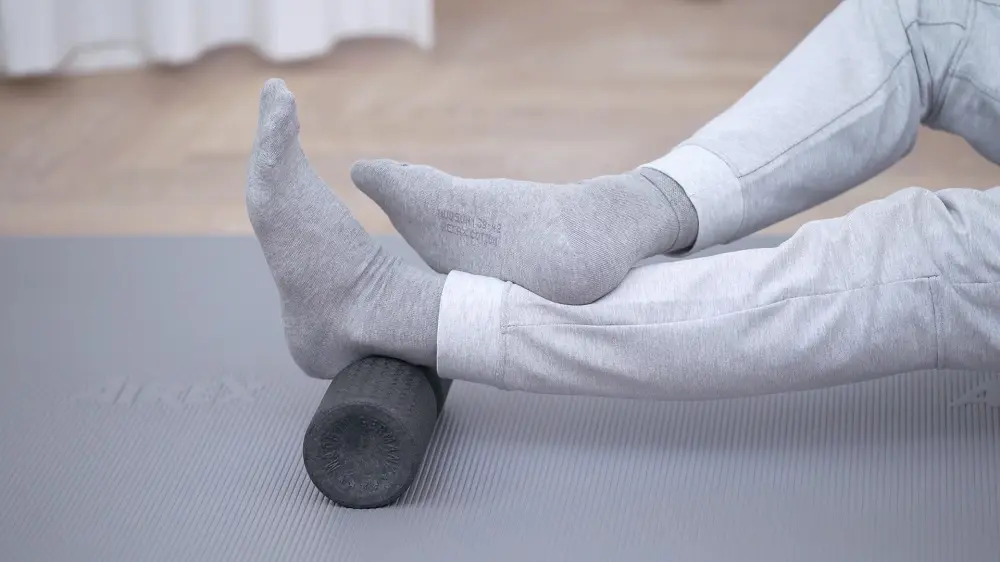 Fersenbein auf einer mittelgroßen Faszienrolle mit Wirbelsäulenvertiefung platziert