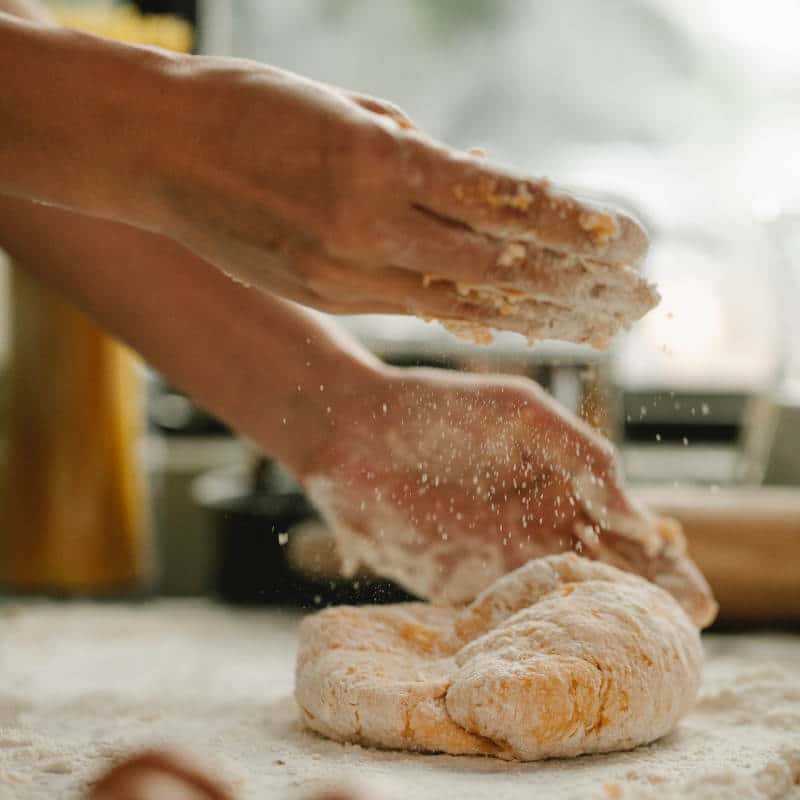 Frauenhände kneten einen Brotteig