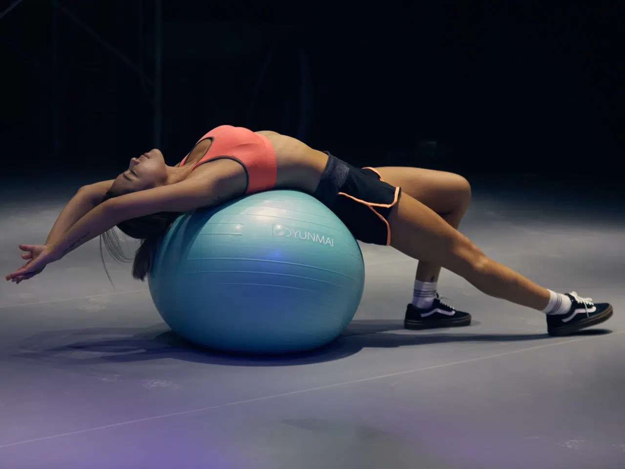 Eine Person liegt mit dem Rücken auf einem Gymnastikball. Sie hat die Arme nach hinten gestreckt und lässt sich passiv hängen. Dabei wird die Brustmuskulatur gedehnt. Die Beine sind nach vorne ausgestreckt, das linke Bein ist leicht angewinkelt, das rechte ist gestreckt.