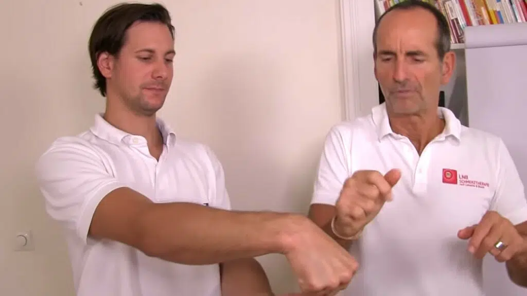 Schmerzspezialist Roland Liebscher-Bracht zeigt die Gegenbewegung, um einen Schnappfinger zu behandeln.