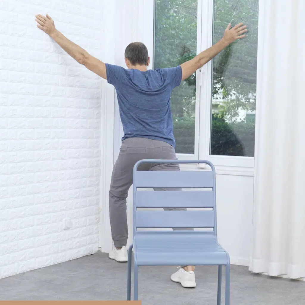 Roland Liebscher-Bracht steht mit weitgespreizten Armen in einer Ecke und beugt sich in sie hinein.