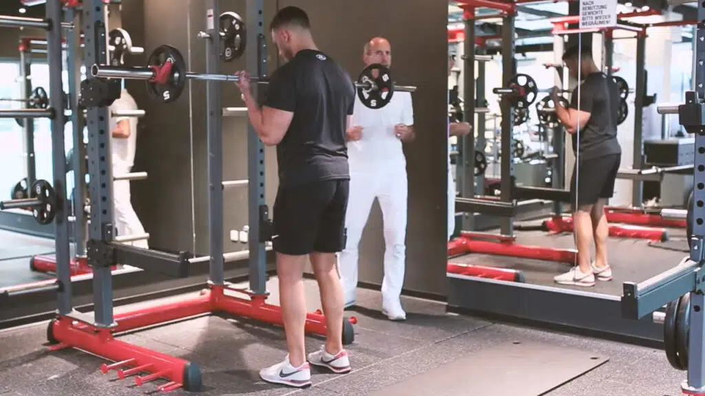 Ein Sportler stemmt im Fitnessstudio eine Hantel.