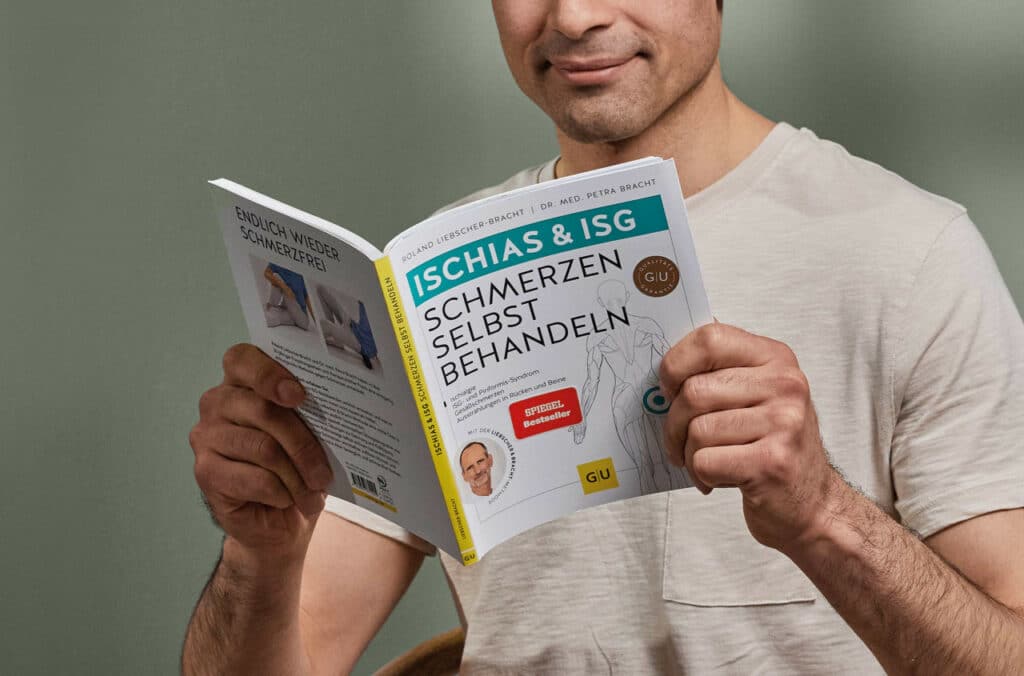 Ein Mann liest im Buch Ischias & ISG Schmerzen selbst behandeln