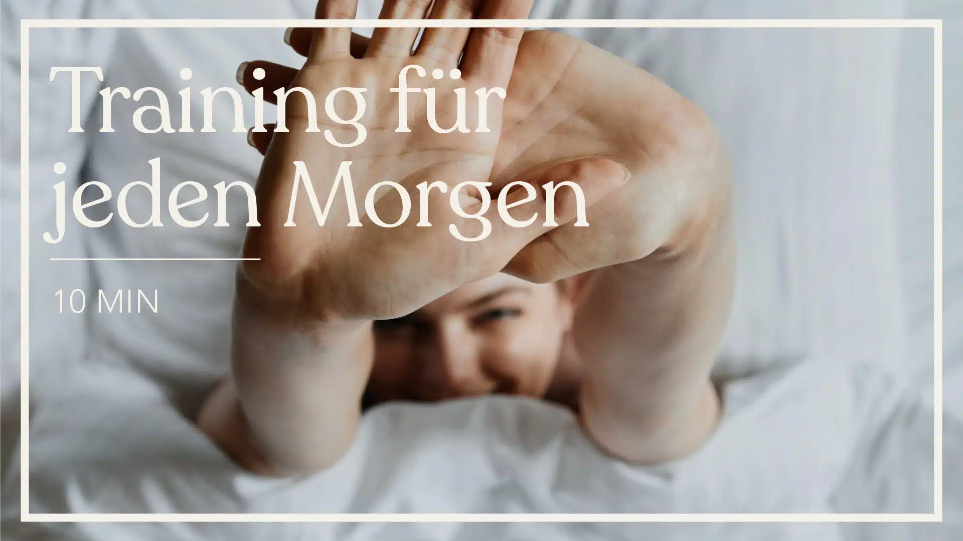 Der Fokus liegt auf zwi Händen, die sich Richtung Kamera strecken. Eine Person liegt dabei im einem weiss bezogenen Bett. Auf dem Bidld steht der Text "Training für jeden Morgen - 10 MIN".
