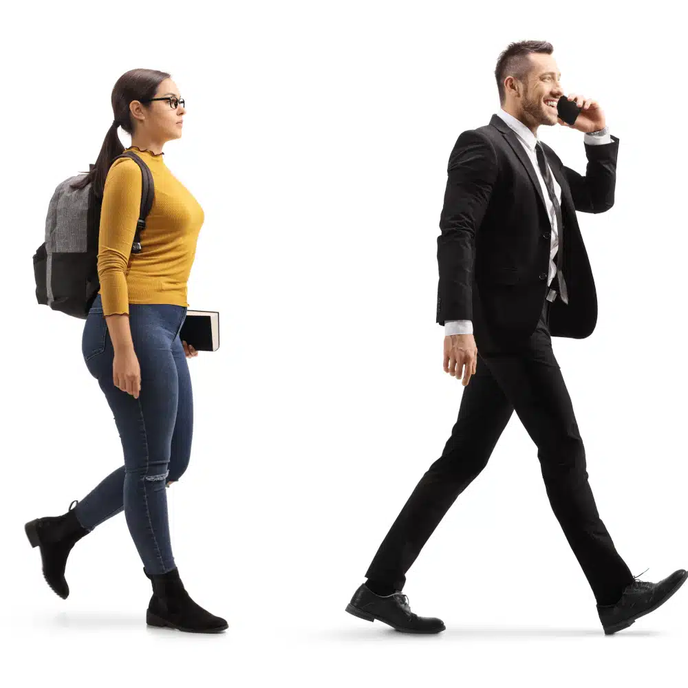 Mann in Anzug läuft telefonierend, dahinter Frau mit Rucksack