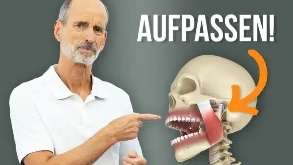 Roland Liebscher-Bracht deutet mit dem Finger auf ein Modell eines menschlichen Schädels. Das Modell zeigt den Verlauf der Kaumuskulatur am Kiefer.