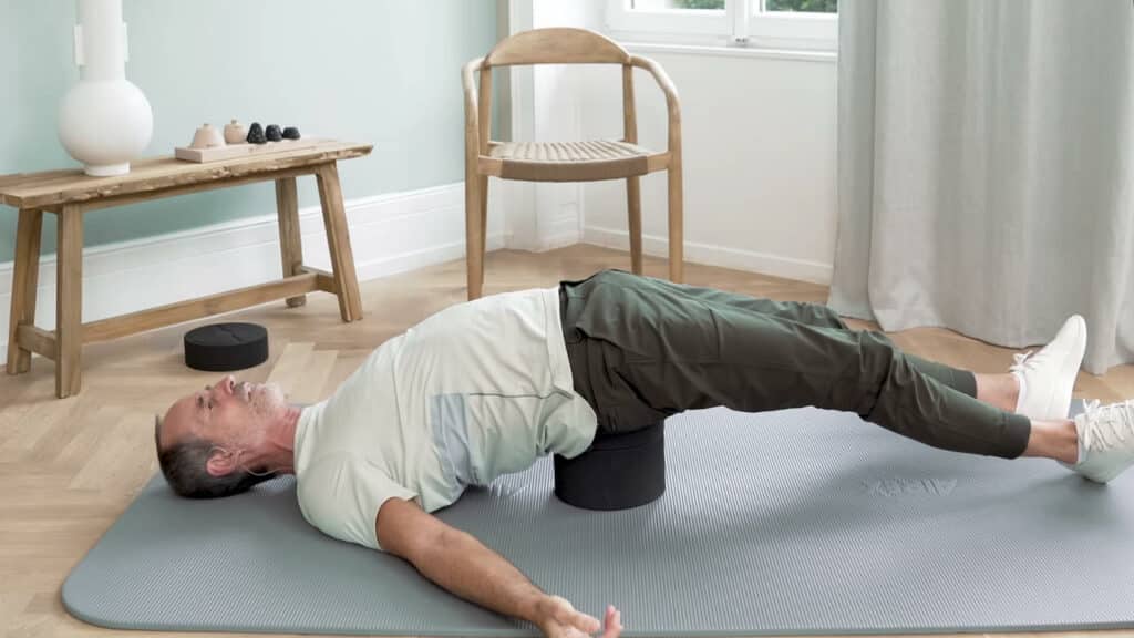 Roland Liebscher-Bracht liegt mit dem Kreuzbein auf dem Rückenretter. Er hat die Beine ausgestreckt und sein Becken wird vom Rückenretter nach oben gedrückt. Kopf und Füße sind also tiefer als das Becken.