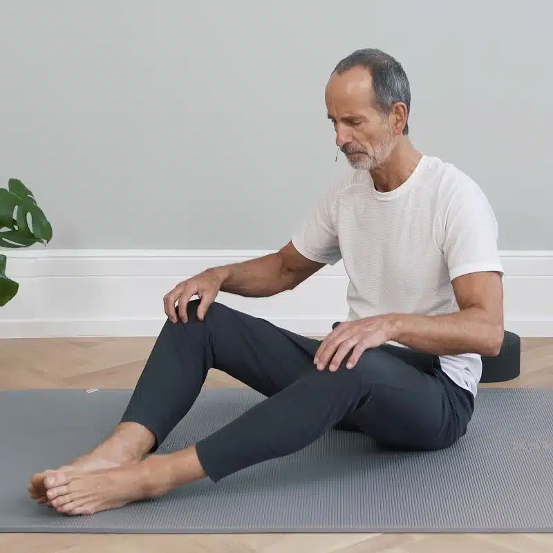 Roland Liebscher-Bracht macht eine Übung am Boden. Seine Beine sind angewinkelt und auseinander gekippt.