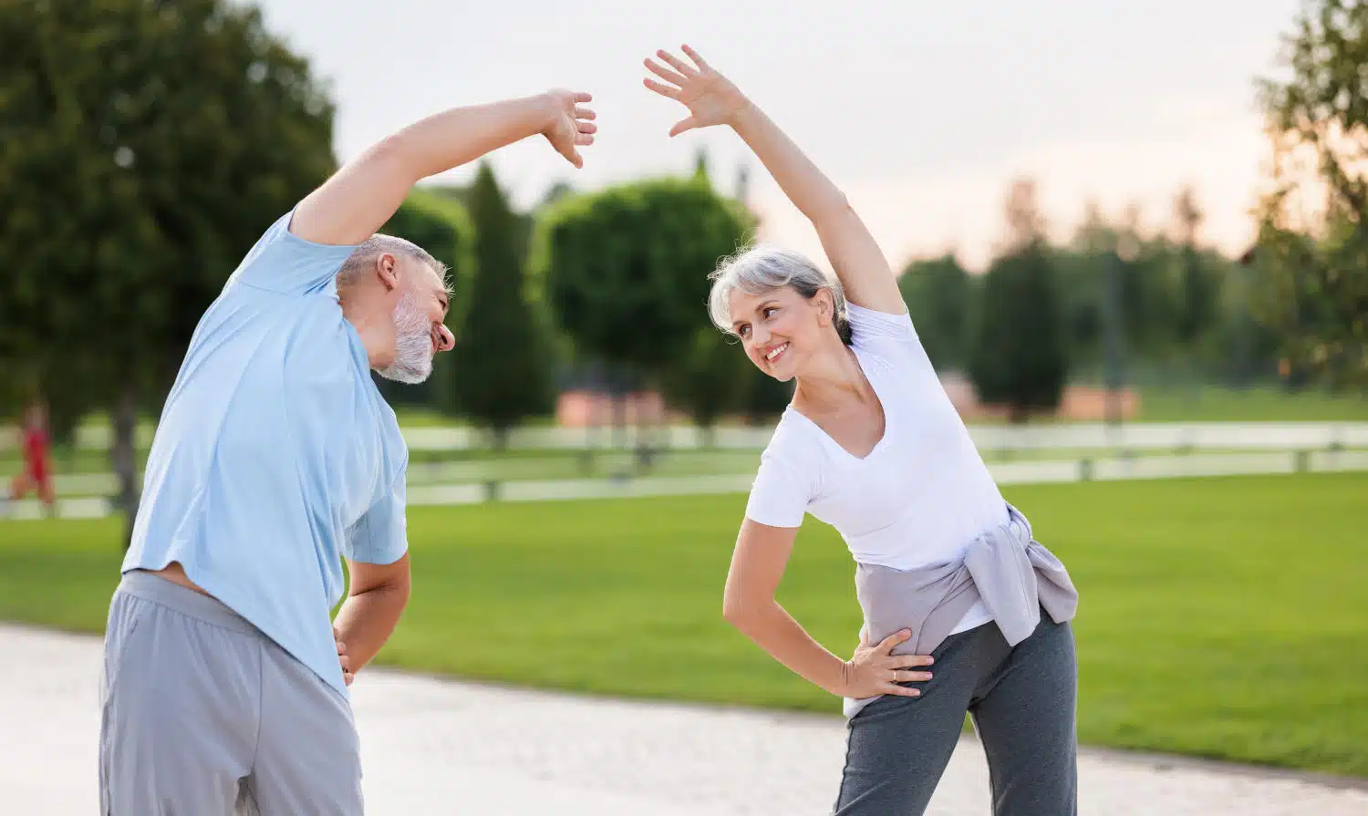 Paar steht in Park und macht Dehnung der Flanken