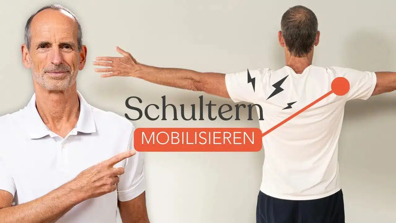 Roland Liebscher-Bracht lächelt in die Kamera und zeigt auf den Text "Schulter mobilisieren". Rechts daneben steht eine weitere Person, die ihre Arme seitlich ausgestreckt hat.