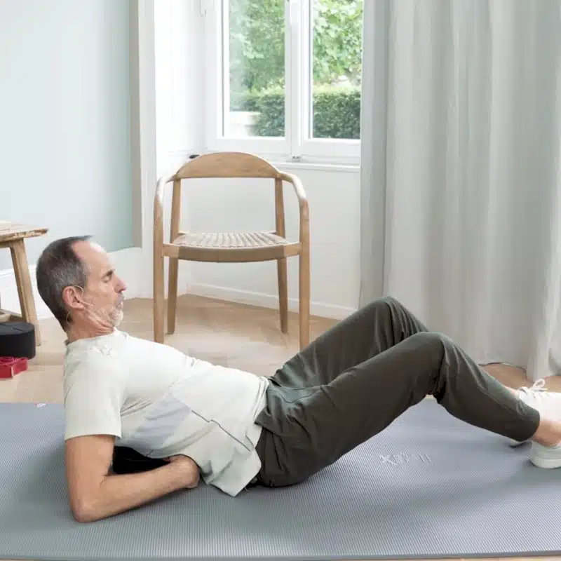 Roland Liebscher-Bracht legt sich auf den Rückenretter, um eine Dehnung für das BWS-Syndrom vorzuführen