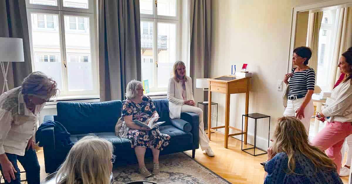 Dr. Petra Bracht sitzt mit einer Gruppe von Menschen in einem Praxisraum und ist in ein Gespräch vertieft