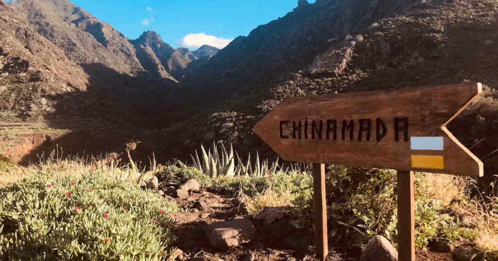 Ein Schild mit der Aufschrift Chinamada weist den Weg in bergiges Gelände