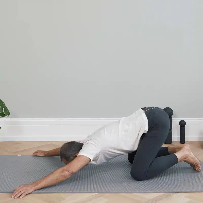 Roland Liebscher-Bracht ist am Boden auf allen vieren. Er hat die Arme nach vorne ausgestreckt und neigt seinen Oberkörper zum Boden.