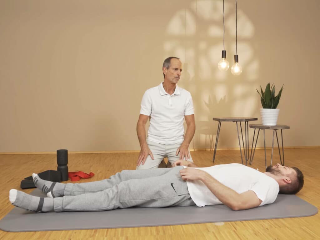 Ein Mann liegt mit dem Rücken auf dem Boden.