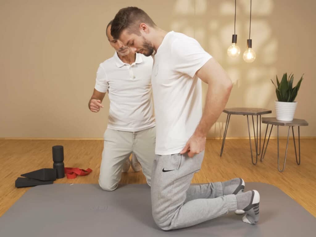 Ein Mann kniet am Boden.