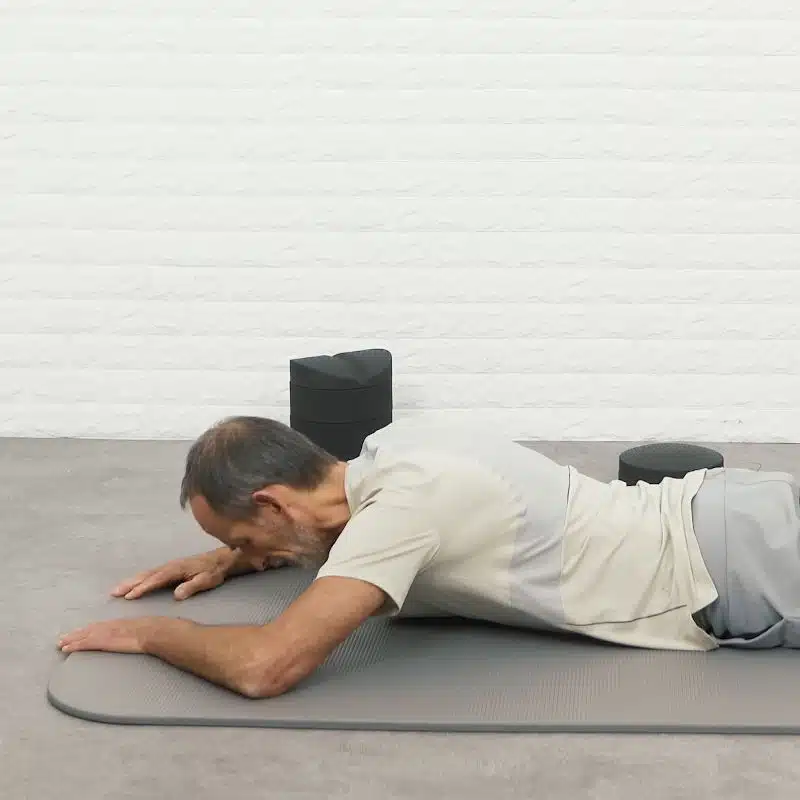 Roland Liebscher-Bracht liegt auf einer Yoga-Matte und schaut mit dem Gesicht zum Boden.