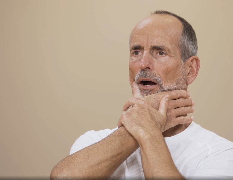 Schmerzspezialist Roland Liebscher-Bracht macht eine Dehnübung für den Kiefer. Seine rechte Hand zieht, unterstützt von der linken, das Kiefergelenk nach rechts