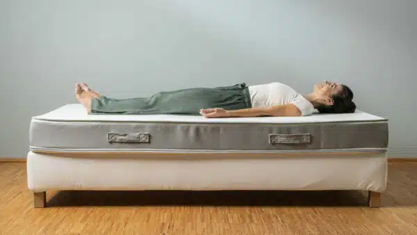 Eine Person liegt in Rückenlage und mit gestreckten Beinen auf der Liebscher & Bracht Matratze.