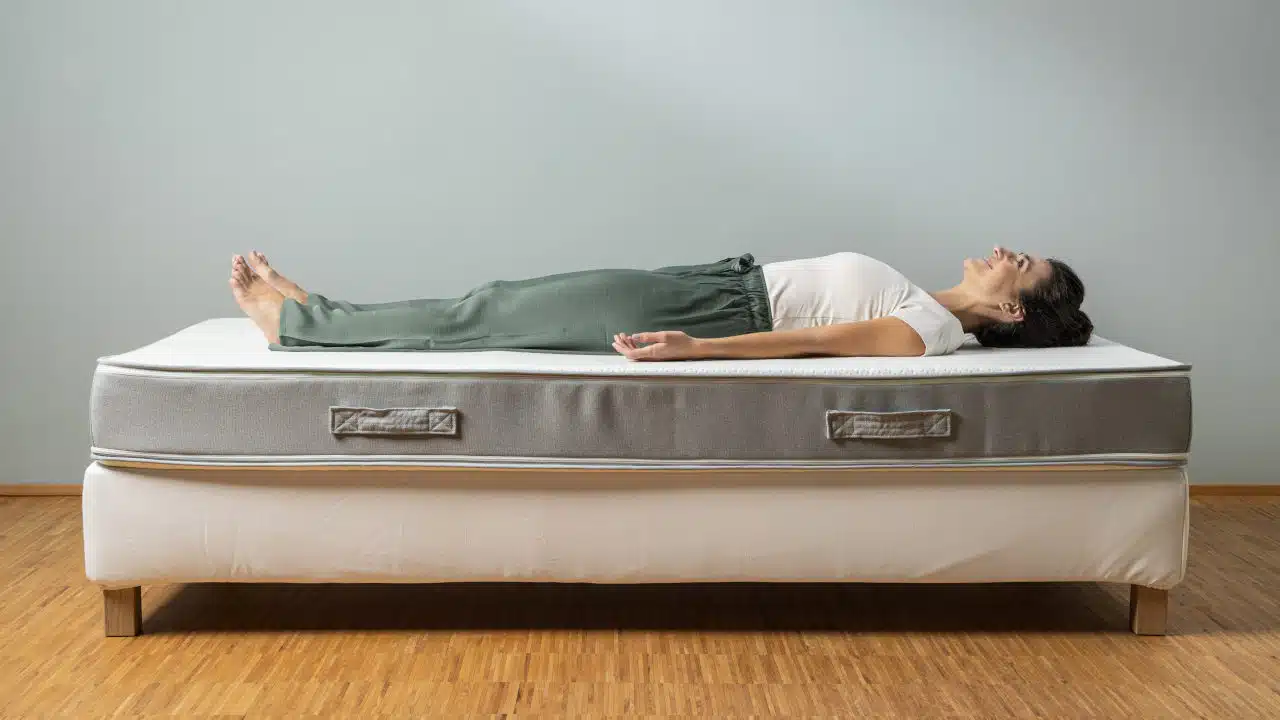 Eine Person liegt in Rückenlage und mit gestreckten Beinen auf der Liebscher & Bracht Matratze.