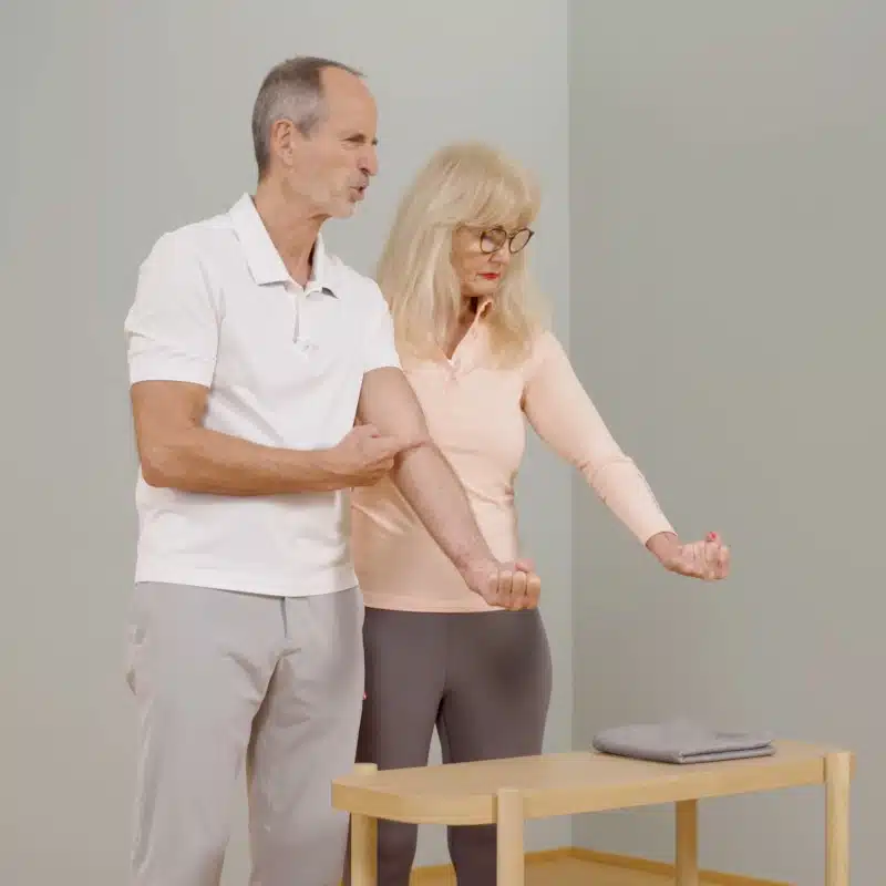 Zwei Personen strecken ihren Arm nach vorne aus und bilden mit der Hand eine Faust.