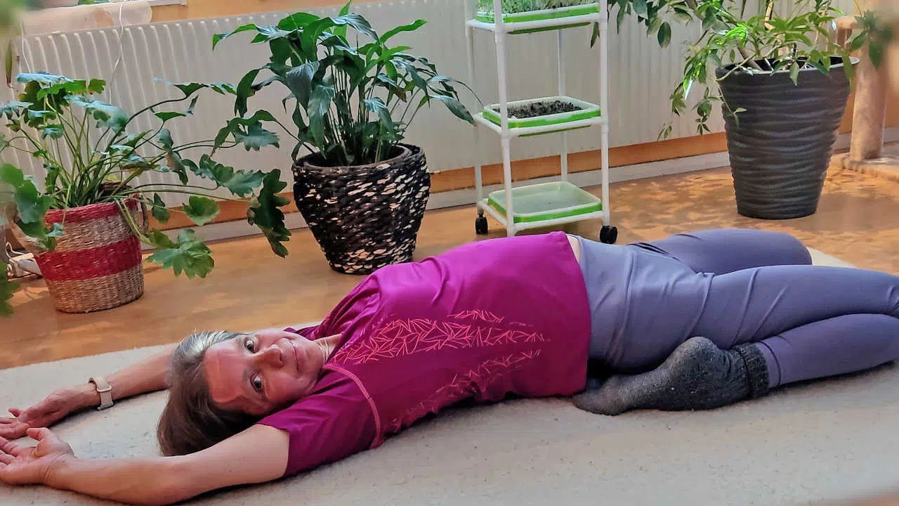 Kerstin liegt auf ihrer Übungsmatte und dehnt sich.