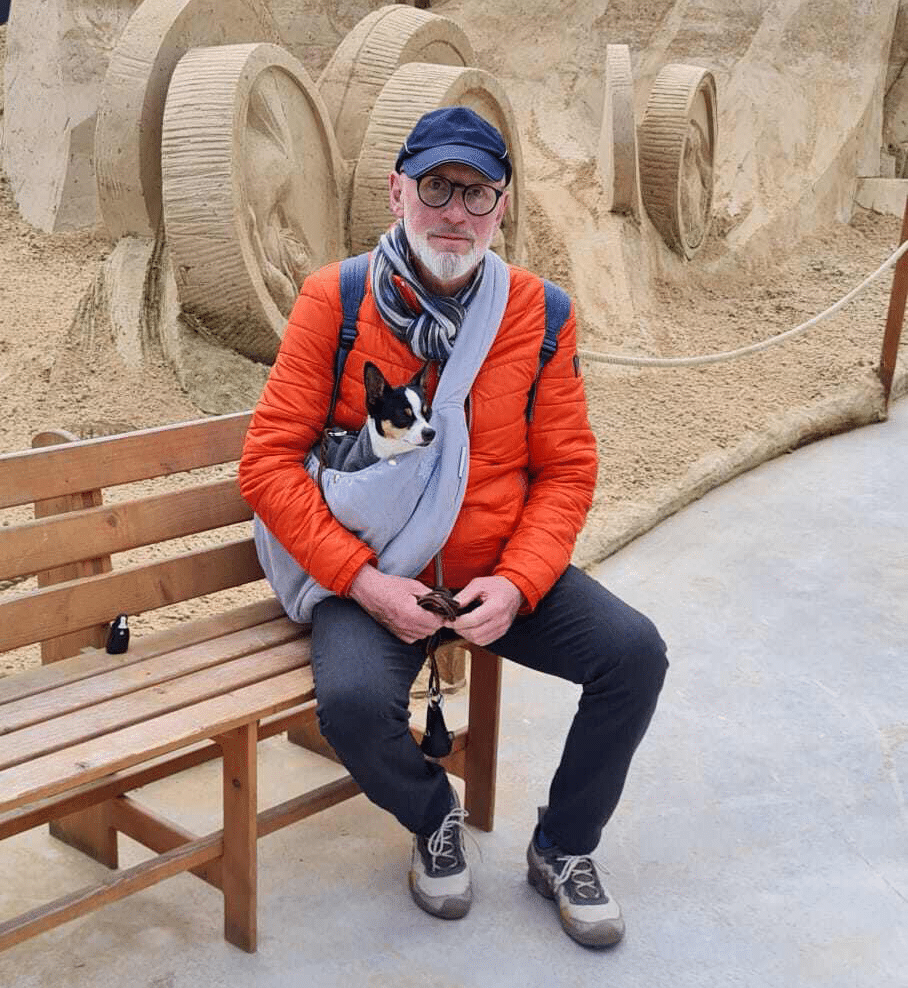Rainer sitzt mit seinem Hund auf einer Bank