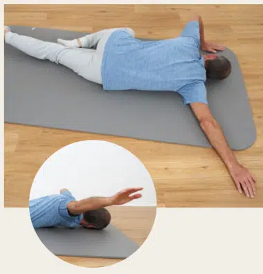 Lege dich in Bauchlage auf den Boden, um die Brust zu dehnen.